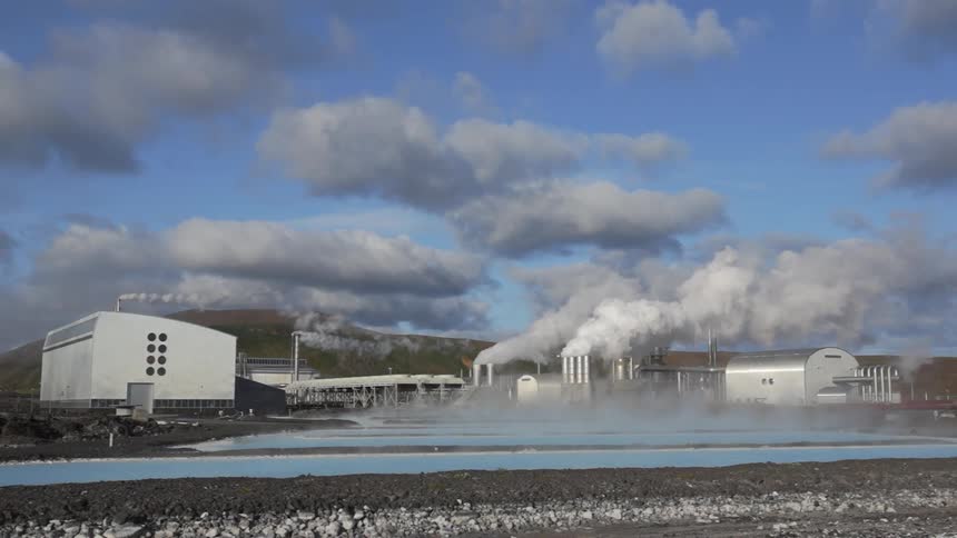 Smoke and steam billow from an industrial plant during the day