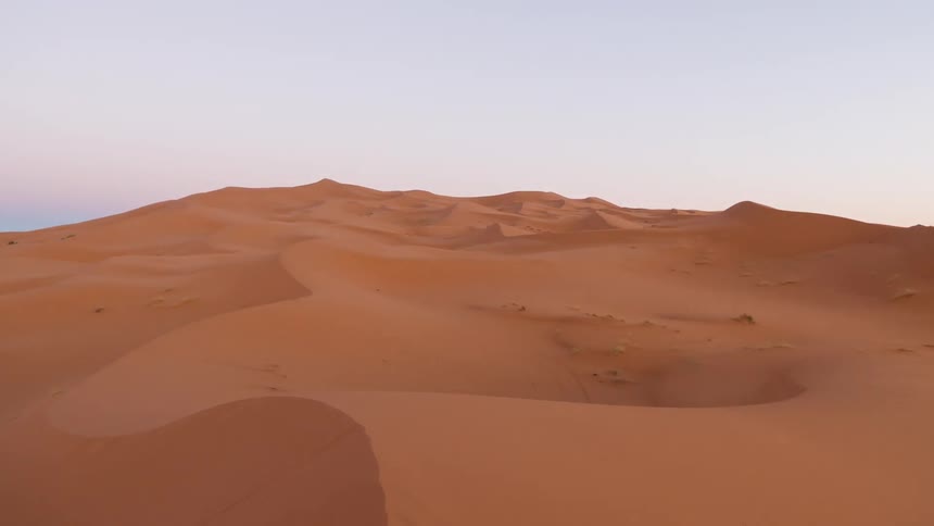 Shadows are creeping across sand dunes as the day progresses
