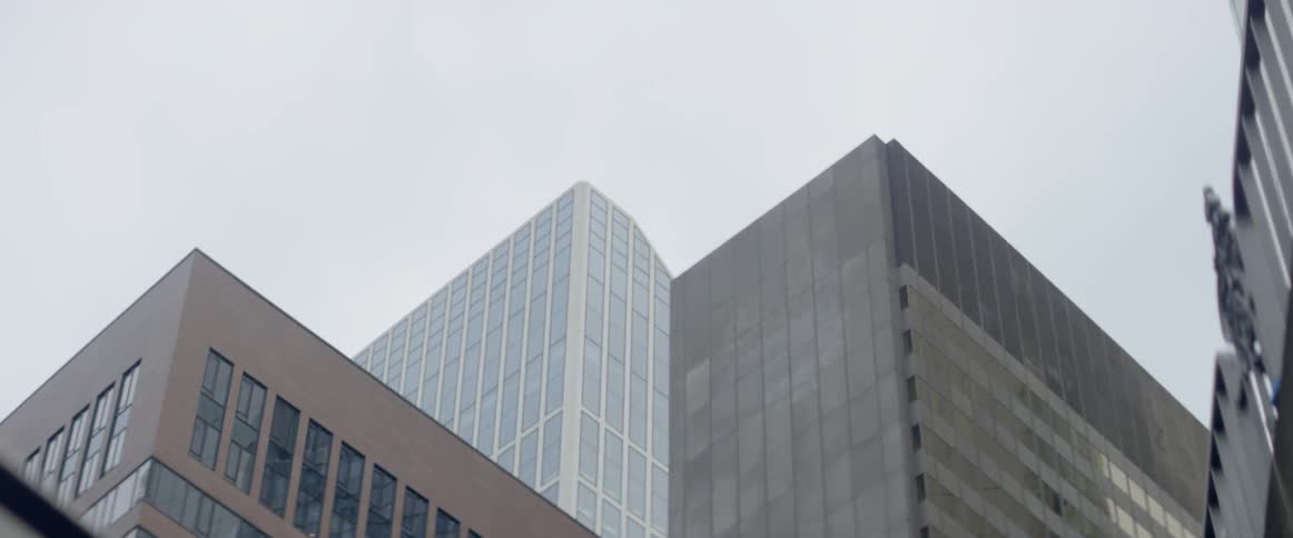 Clouds are hovering in the sky above high rises in the city during the day