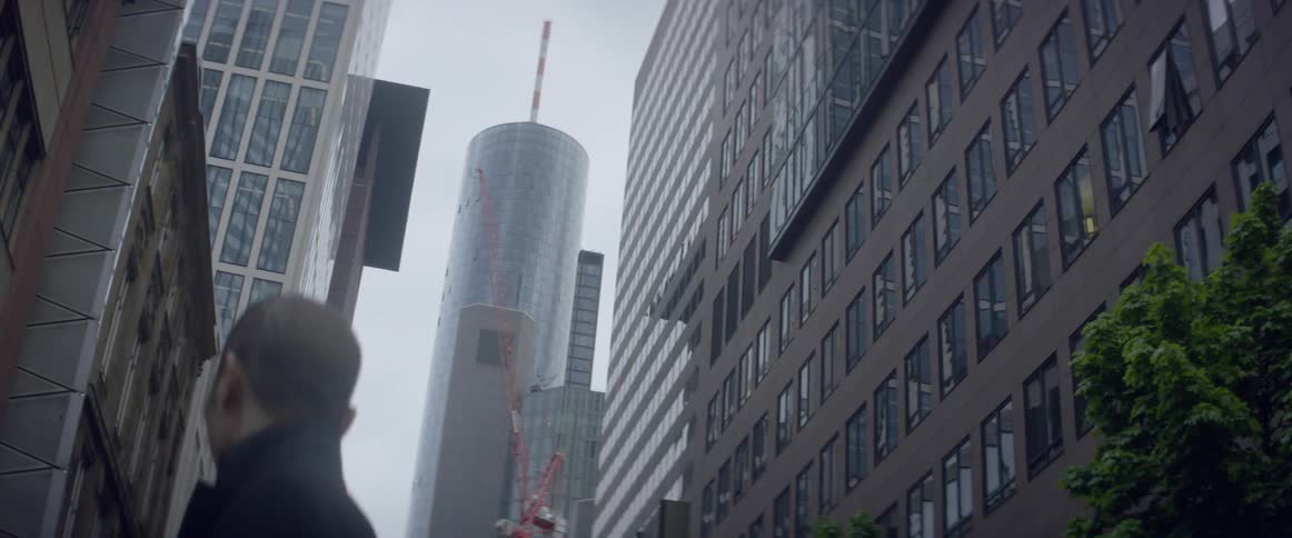 Pedestrians walk by city skyscrapers