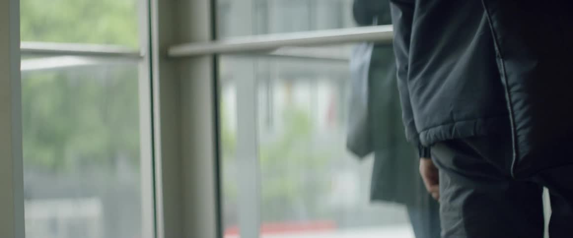 People are walking through a revolving door out of a building during the day
