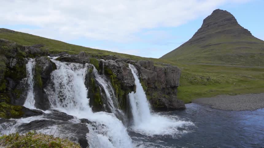 Water rushing over some small falls and flowing into the basin area on a cloudy day