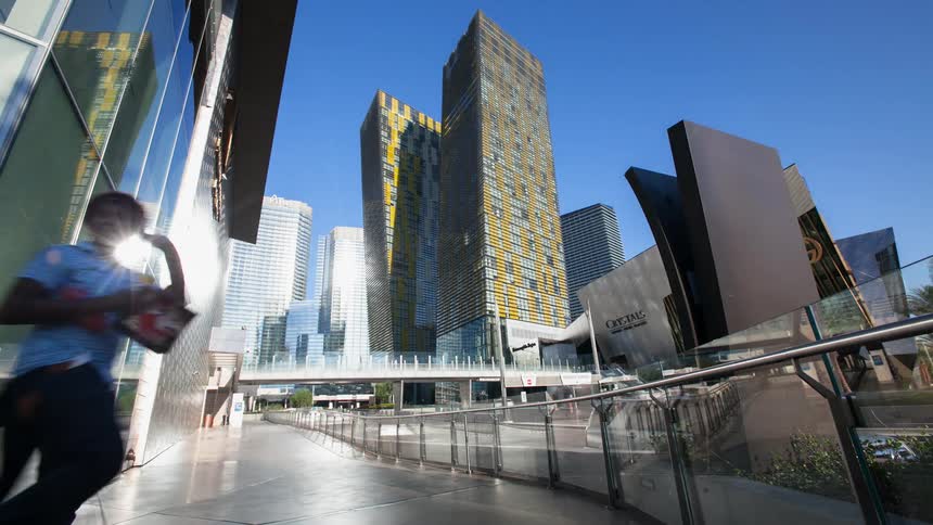 People walking down a sidewalk near tall skyscrapers