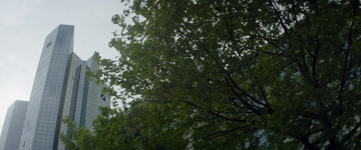 Clouds are hovering in the sky above a skyscraper and high rise during the day