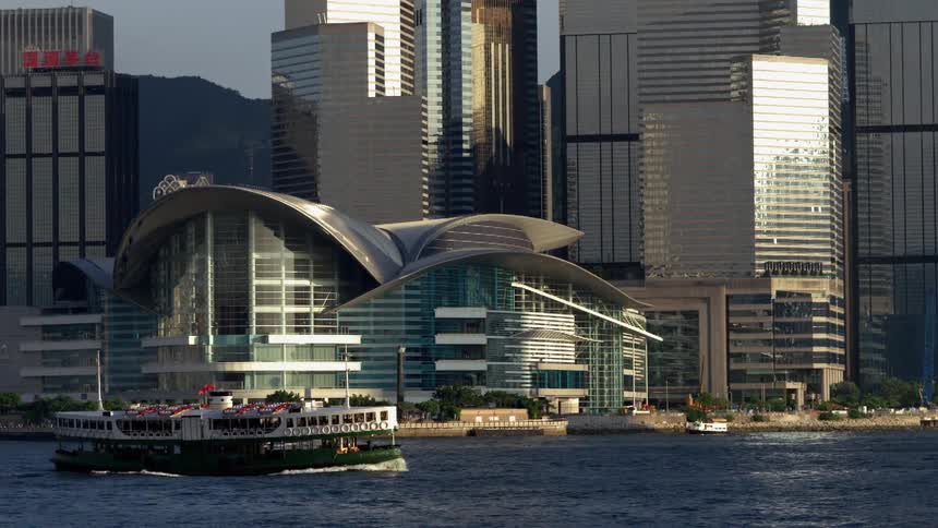 A boat floats near skyscrapers