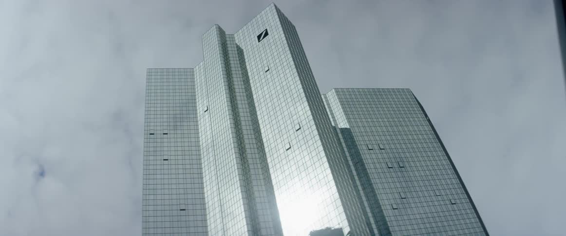 Clouds are hanging above the tops of skyscrapers in a city during the day