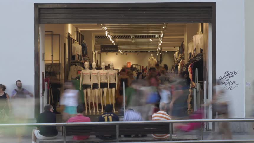 Time-lapse of people and traffic moving past a large store opening