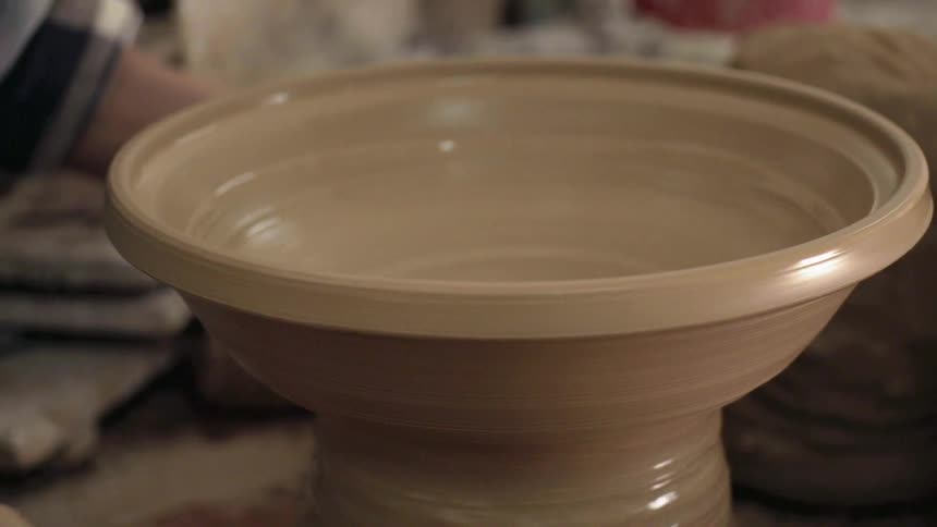 A bowl is shaped on a pottery wheel
