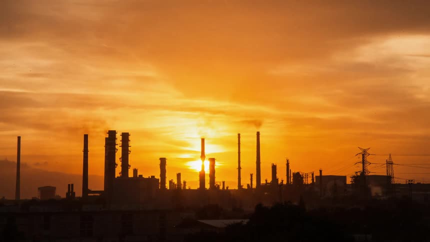 The sun sets over a factory