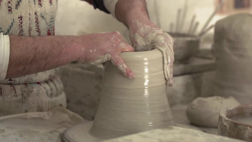 Someone is creating a pot out of clay