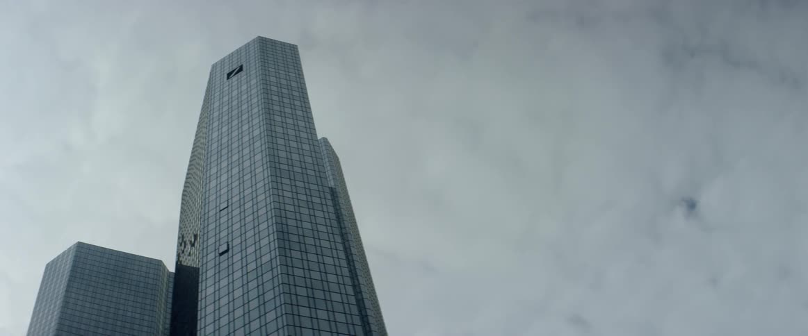 Tall building standing in a large city against a cloudy sky