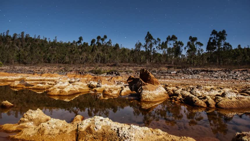 A river flows beneath swirling stars in the sky