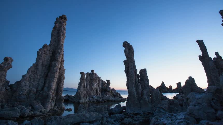 Ocean water shimmers around the rock formations at sunrise