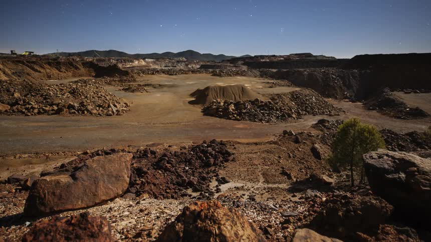 Stars are moving in the sky above a desert landscape
