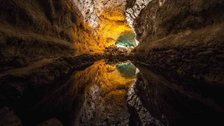 A pool of water sits in a cave