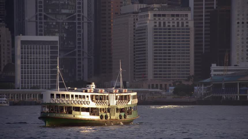 A boat floats on a river near skyscrapers
