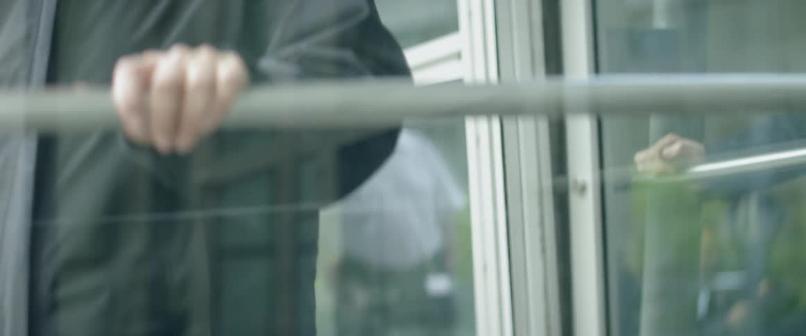 People push through a building's revolving door and exit