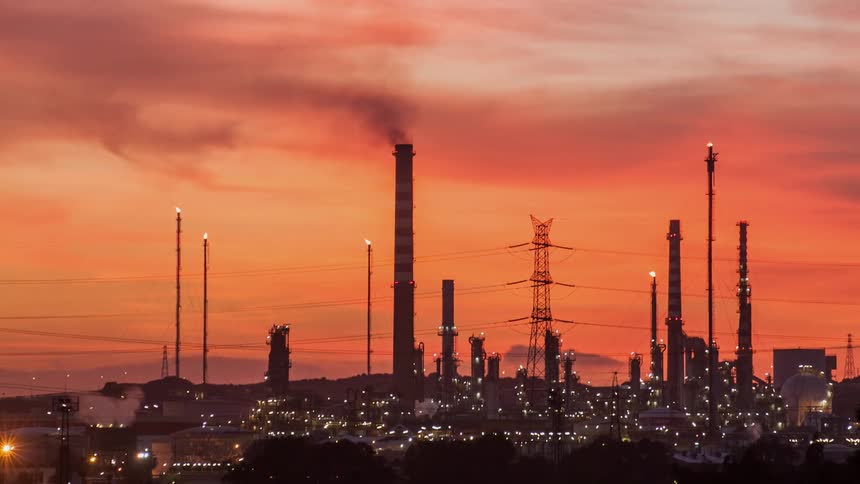 Smoke flows from an industrial smoke stack as dusk progresses