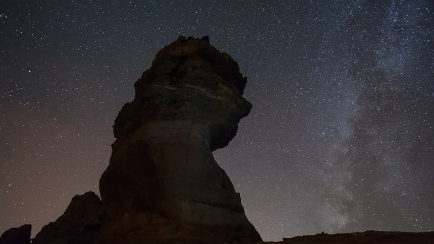 Stars move across the sky over rock formations