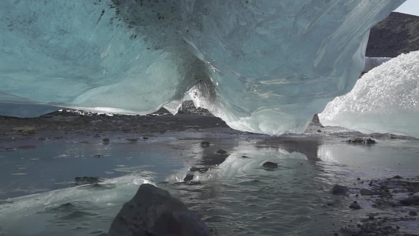 Water flows beneath a glacial ice-shelf during the day