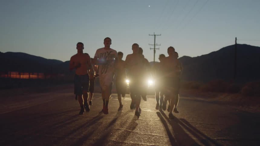 People running in front of a car