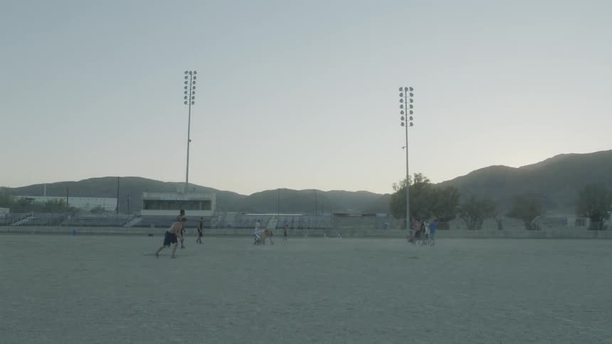 Group of men plaay football near the mountains