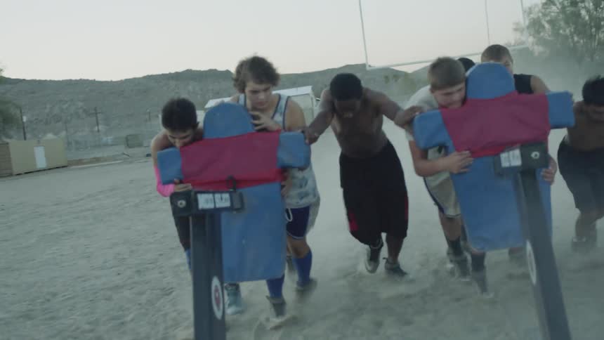 People pushing a football sled
