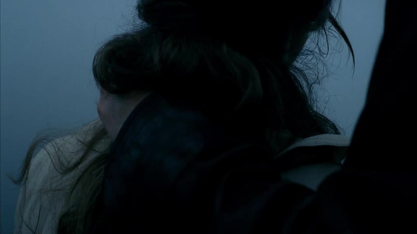 A man wraps his arm around a woman and kisses her