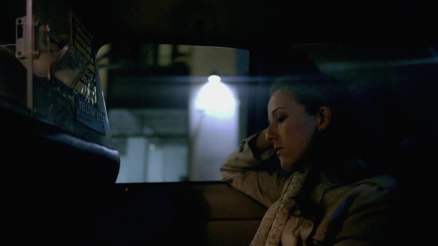 A woman rides in the back of a taxi