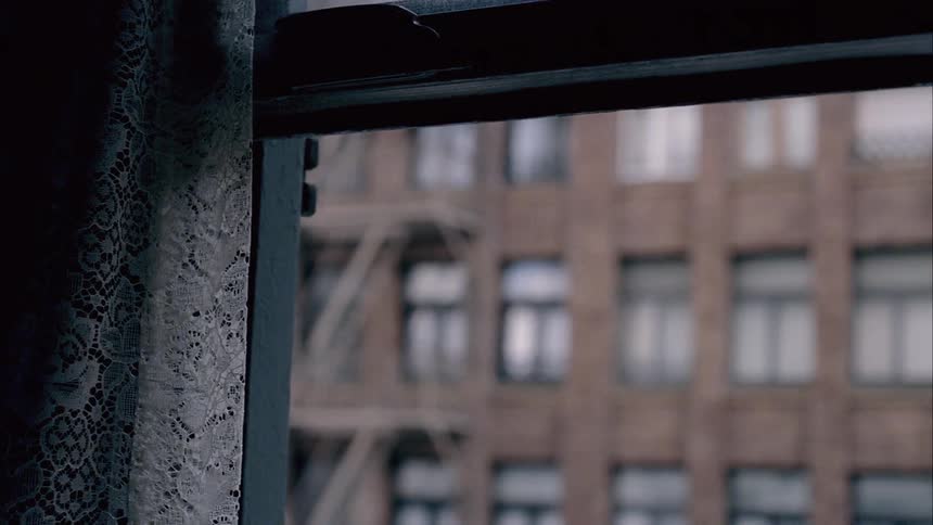 Open window with a large building across the street