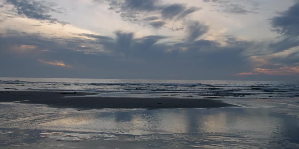 Waves roll on shore on a cloudy day