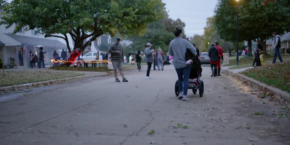 People walking outside down a road on halloween