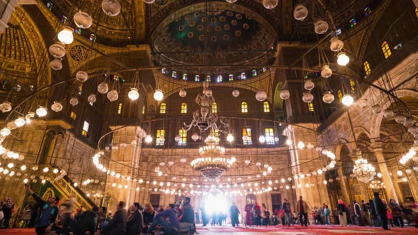 People walk inside an ornate building