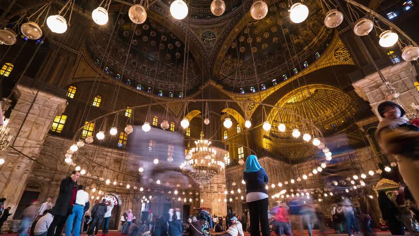 People walk inside an ornate building