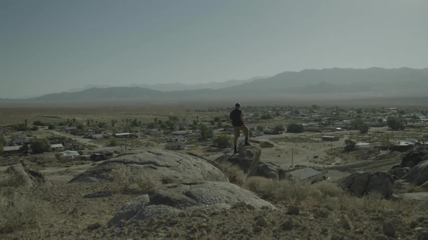 Man walks across some rocks on a cloudy day
