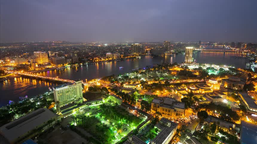A river flowing through a lit up city at night