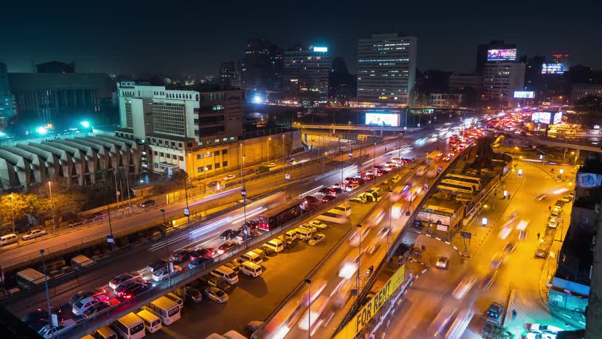 Cars drive on a city street at night