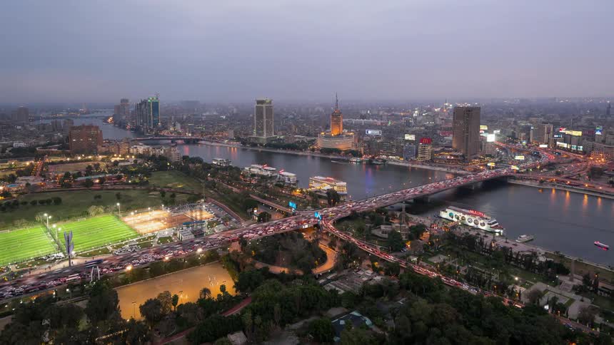Vehicles travel on a city road and bridge at night