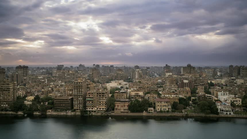 Clouds float over a city at sunset