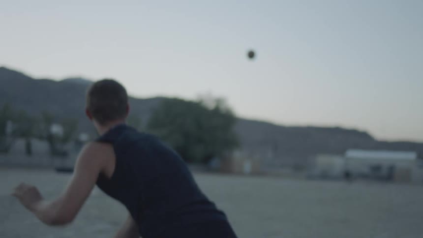A football is hiked to a man and he throws it to someone running