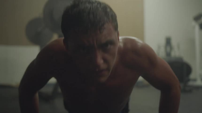 Man doing pushups as people count them out