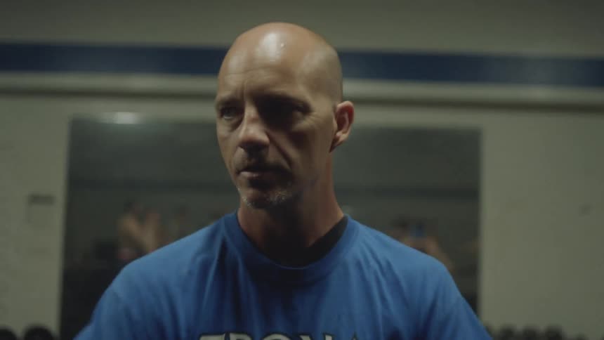 A man leads young men in a gym workout