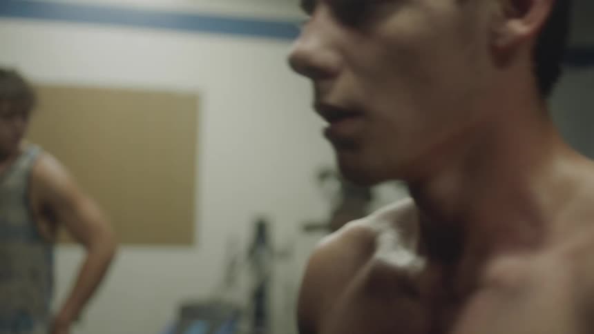 Shirtless man breathes heavy as he walks forward