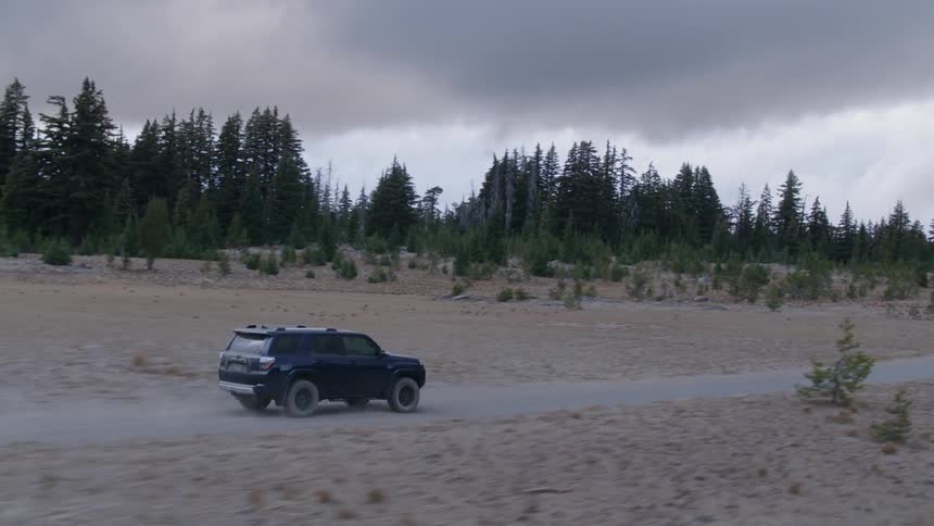 A truck drives on a dirt road