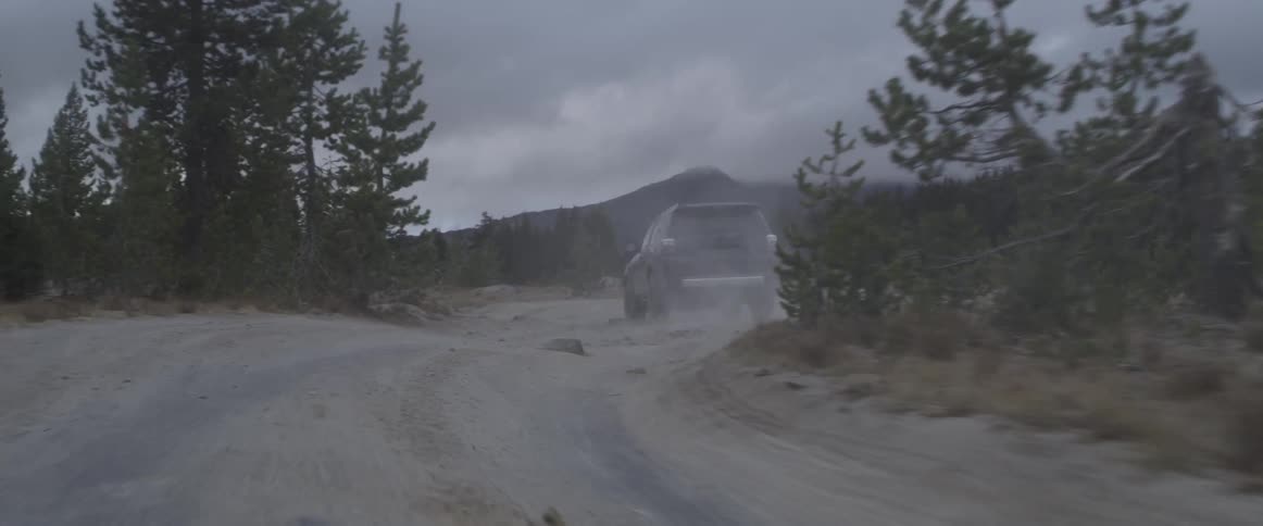 A truck drives on a dirt road