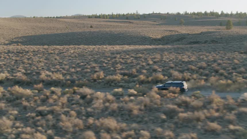 A truck drives on a dirt road