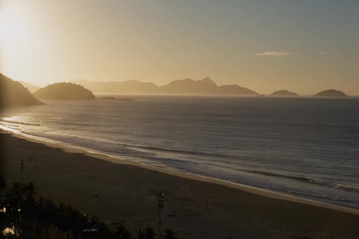 The tide is lapping a shoreline as the sun rises