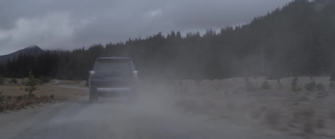 An suv takes a corner quickly on a dirt road