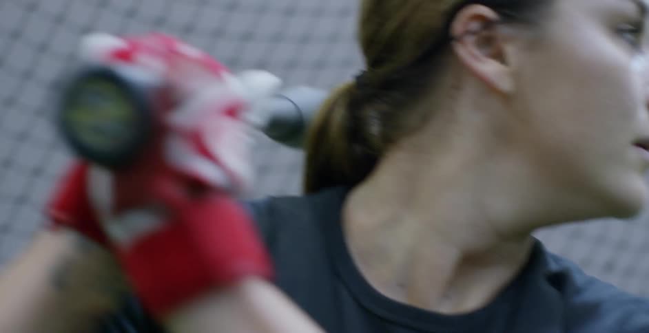 Woman swings baseball bat over her shoulder