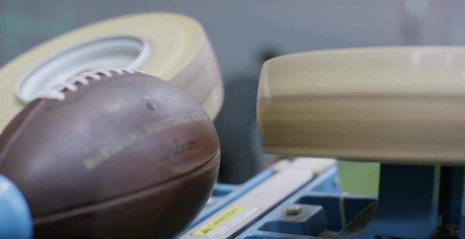 Man catches a football that was shot from a machine